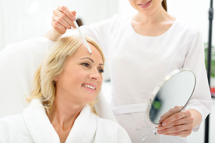 Frau bekommt Reinigung vor Gesichtsbehandlung