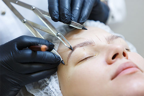 Frau bekommt die Augen fürs Microblading vermessen