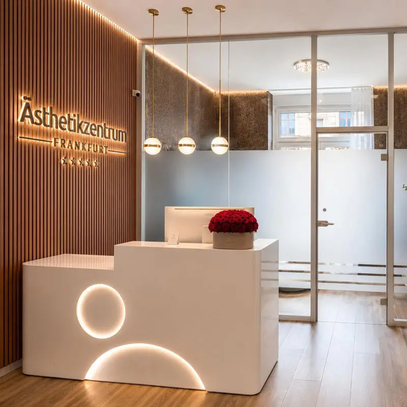Empfangsbereich des Ästhetikzentrums Frankfurt mit modernem Empfangstresen und hochwertigem Praxisdesign